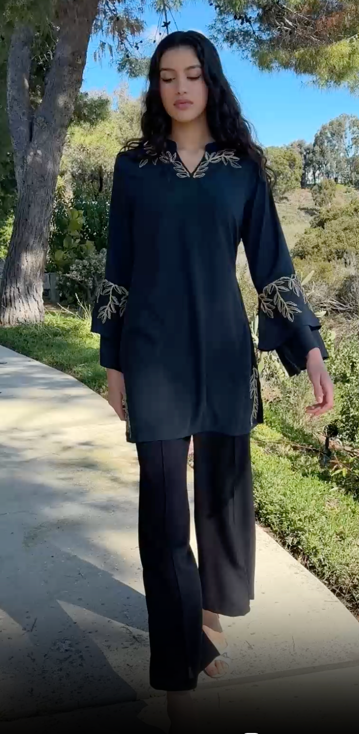 Woman walking outside wearing modest Arzoo tunic in Dark Teal with black pants and heels. 