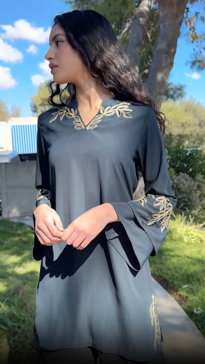 Woman looking to the side outside wearing Arzoo tunic in Dark Teal. 