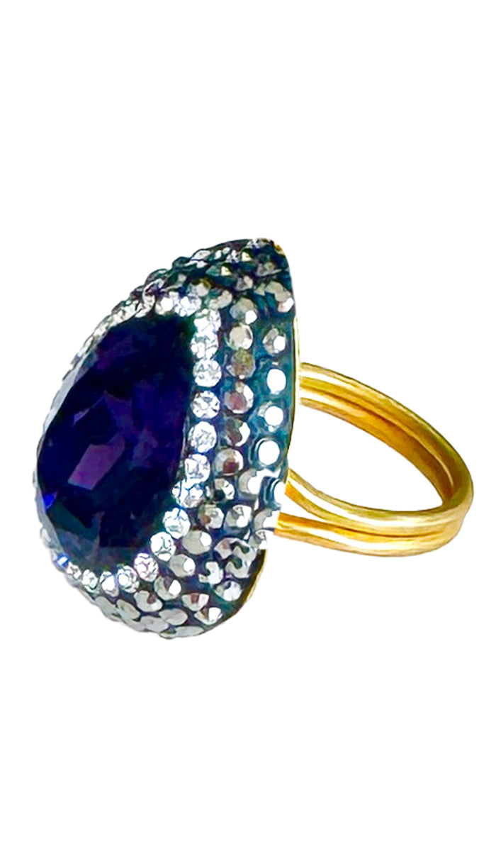 Side profile of teardrop ring with purple jewel and CZ crystals.