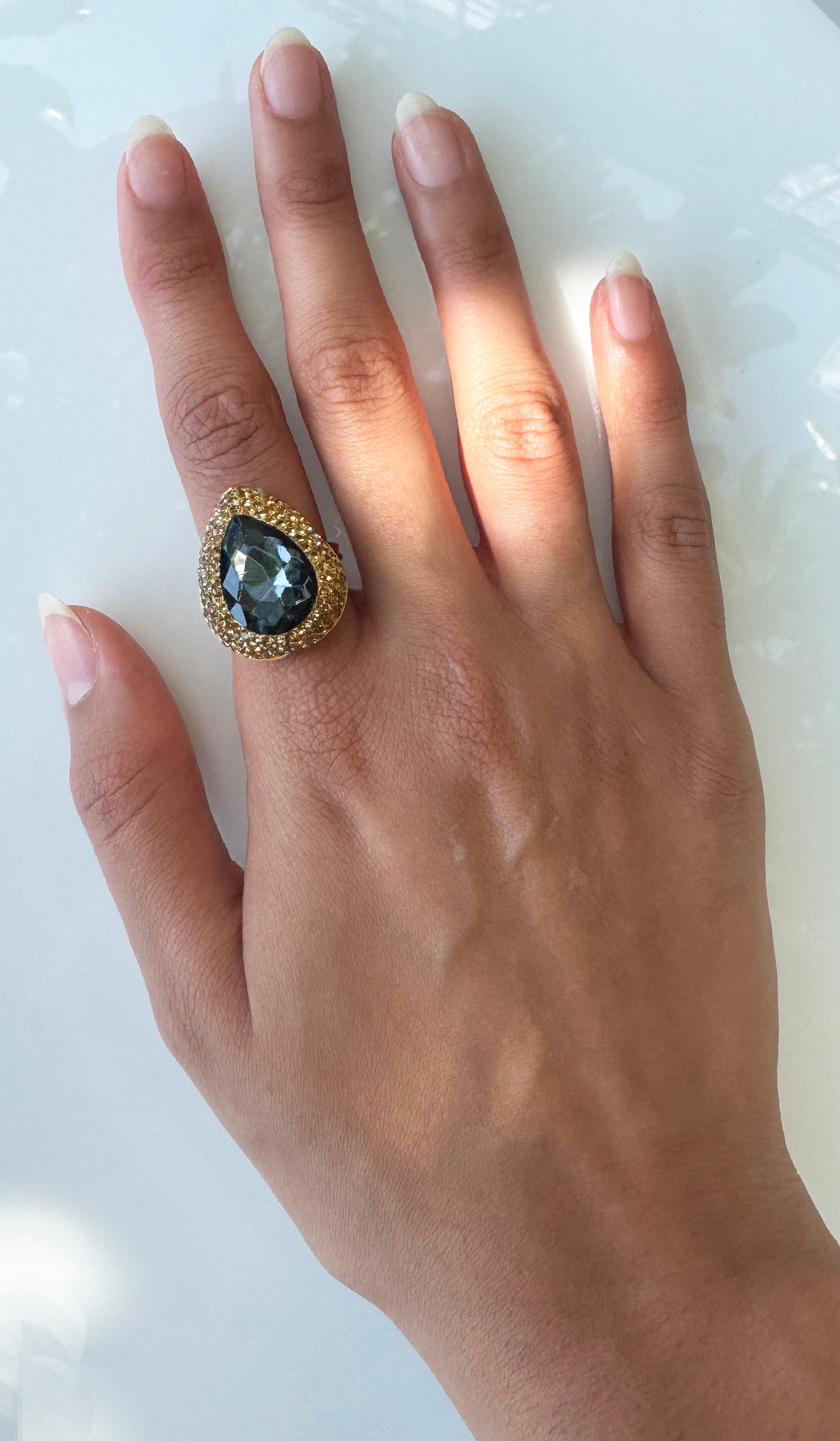 Hand wearing smoky crystal teardrop ring.