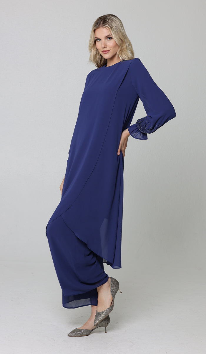 Model wearing Safa tunic and pants in blue with silver heels.