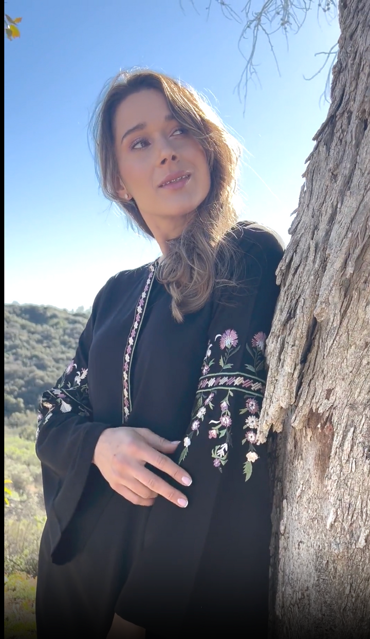 Model posed outdoor by tree surrounded by hills wearing the Gulzar tunic in Black. 