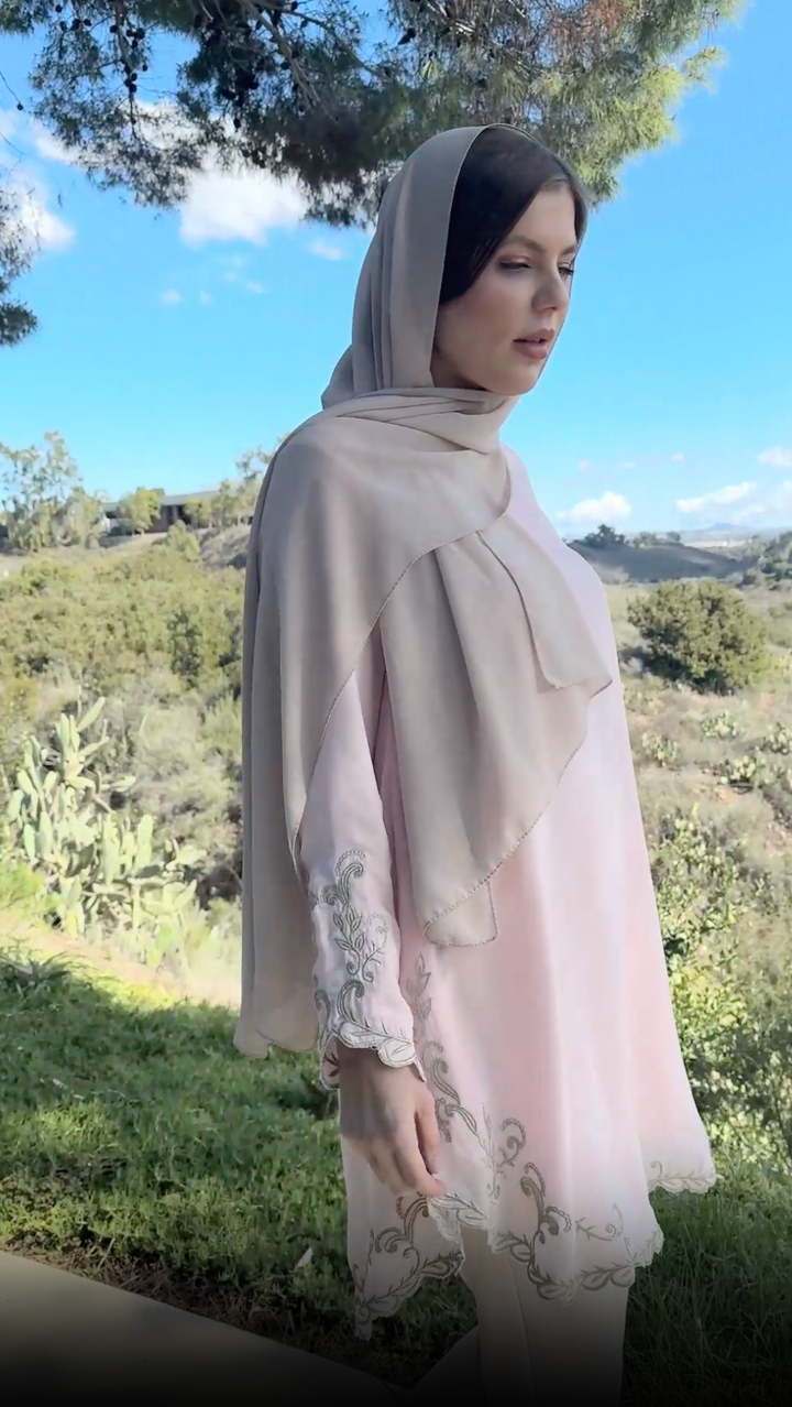 Model in lush green background wearing blush pink Meena tunic and hijab. 