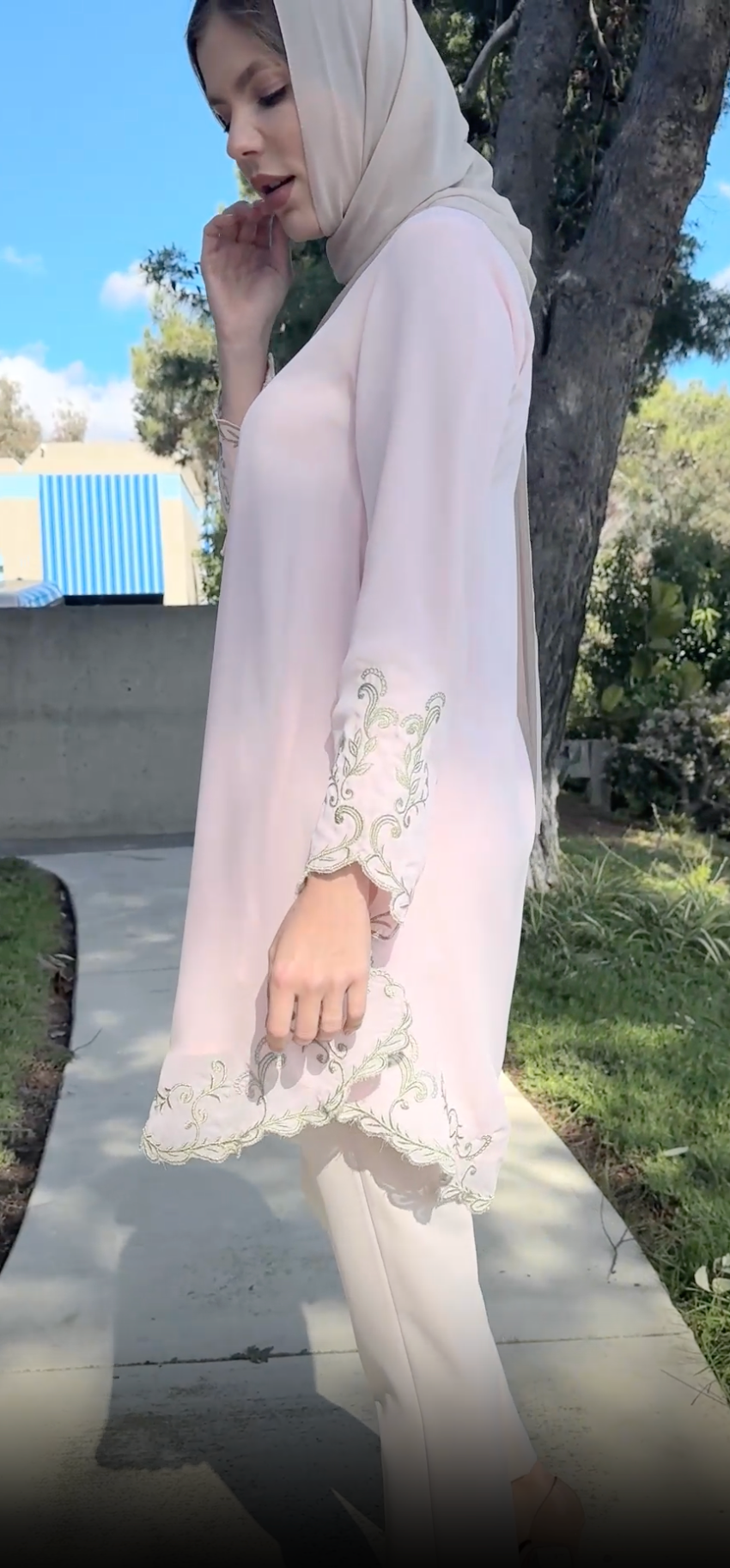 Side view of model wearing hijab and Meena tunic in pink.