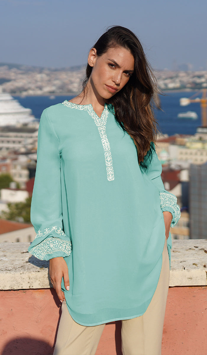 Model on rooftop wearing Amalie tunic in Aqua Blue with khaki pants. 