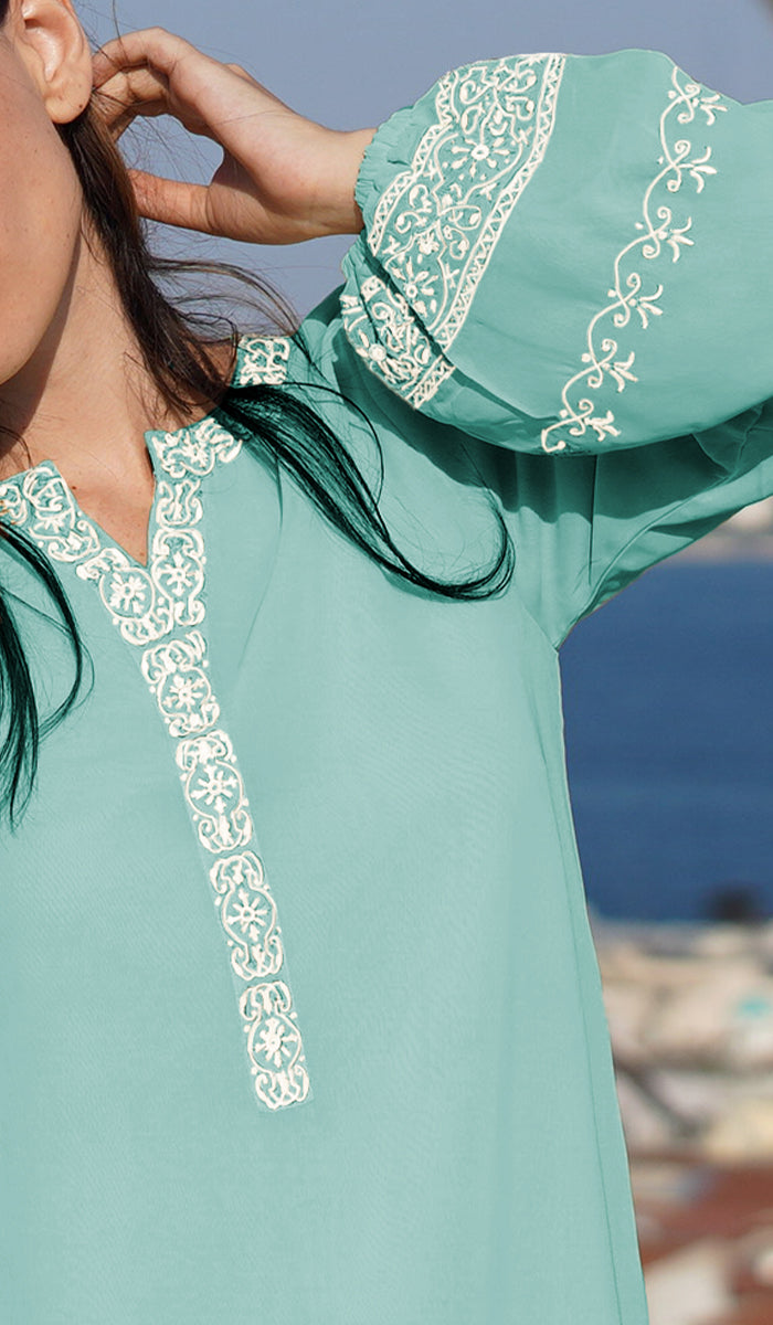 Sleeve and neckline details of the Amalie tunic in Aqua Blue. 