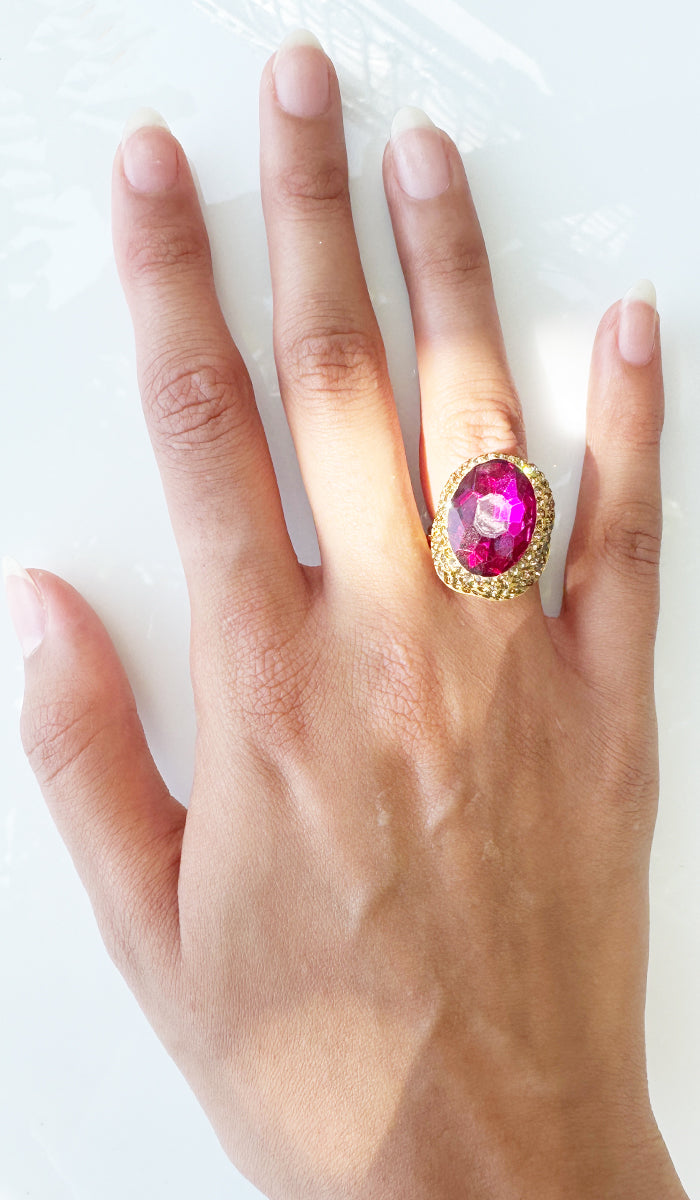 Hand wearing hot pink oval ring.