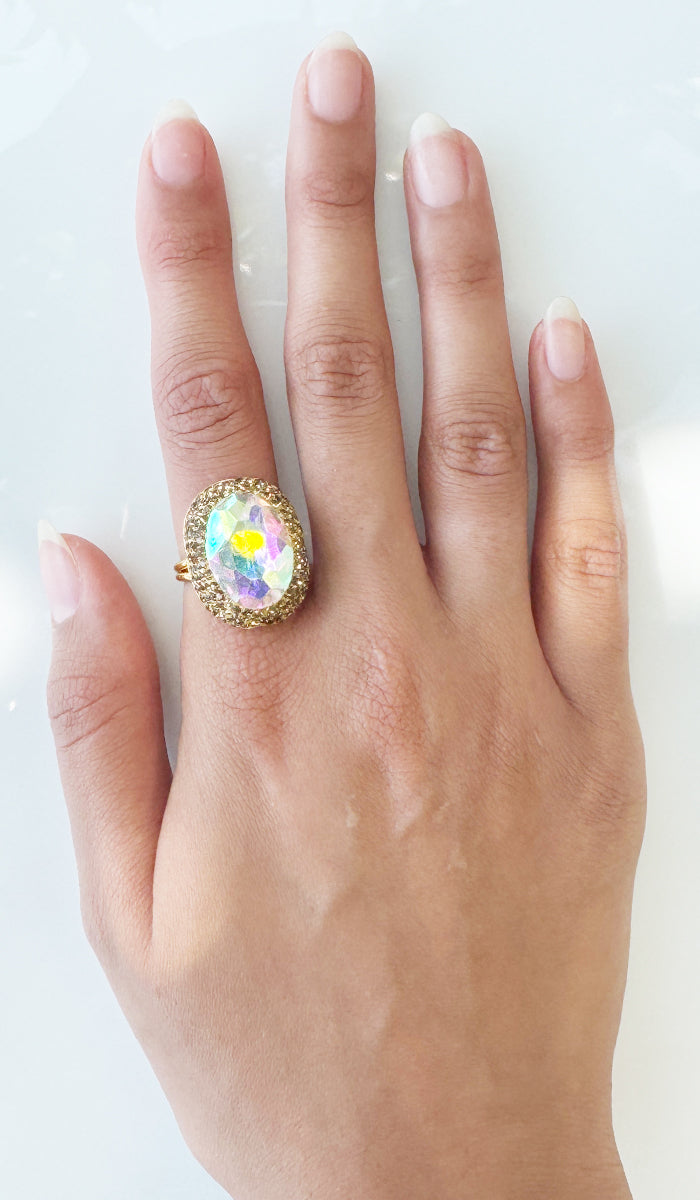 Hand wearing rainbow oval ring.