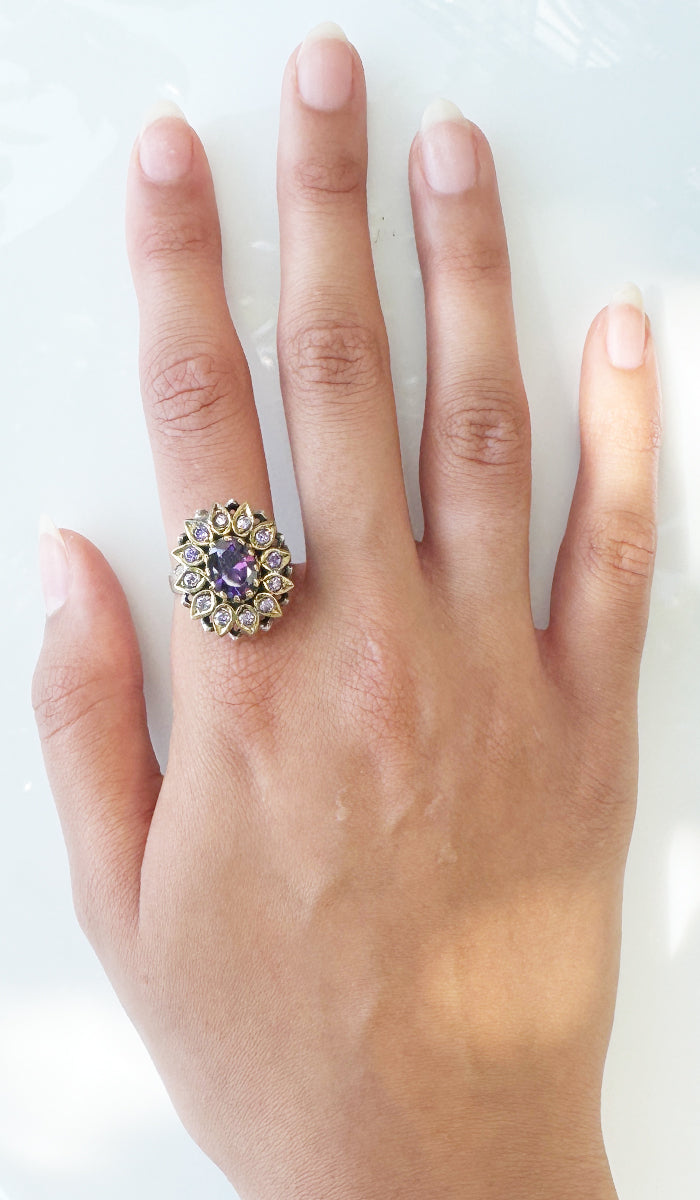 Hand wearing purple ring.