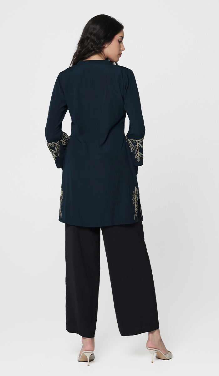 Back view of woman wearing Arzoo tunic in Dark Teal with black pants and heels. 