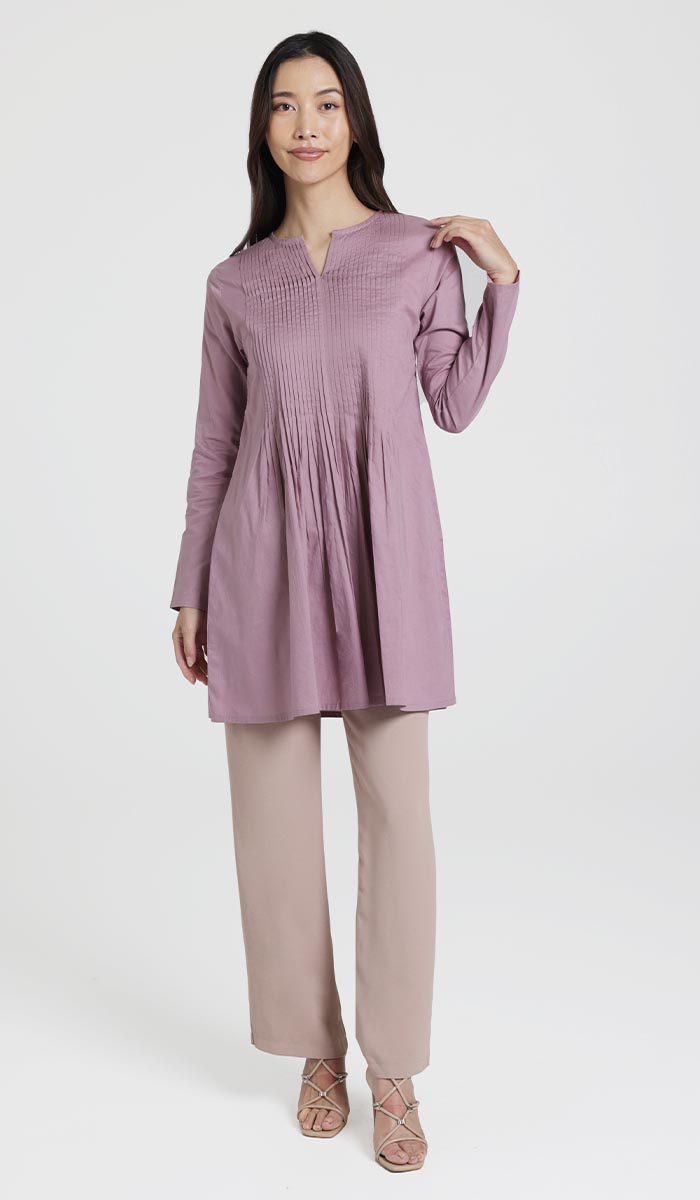 Woman wearing Asman tunic in Dusty Mauve with pants and heels. 