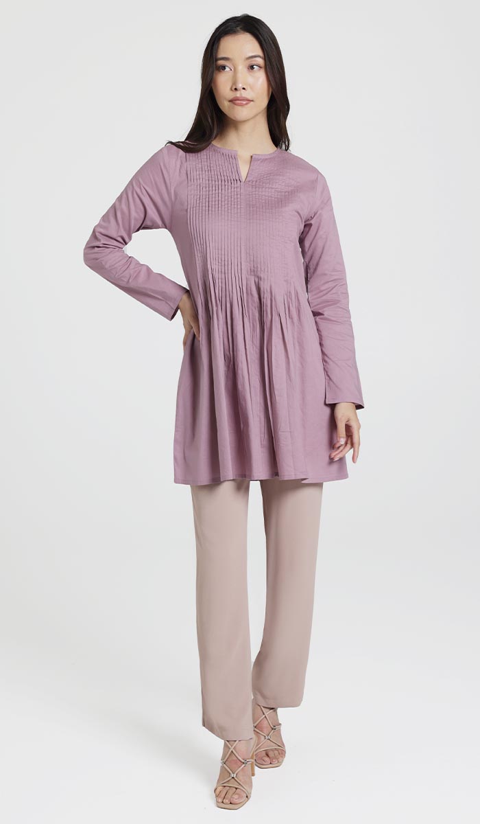 Woman with hand on hip wearing Asman tunic in Dusty Mauve with pants and heels. 