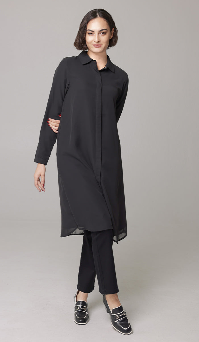 Smiling woman wearing Asra tunic in Black with black pants and loafers. 