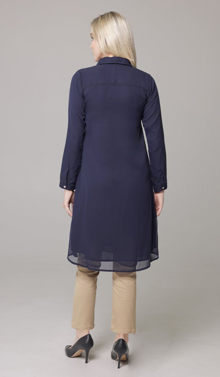 Back view of woman wearing Asra tunic in Navy with khaki pants and heels. 