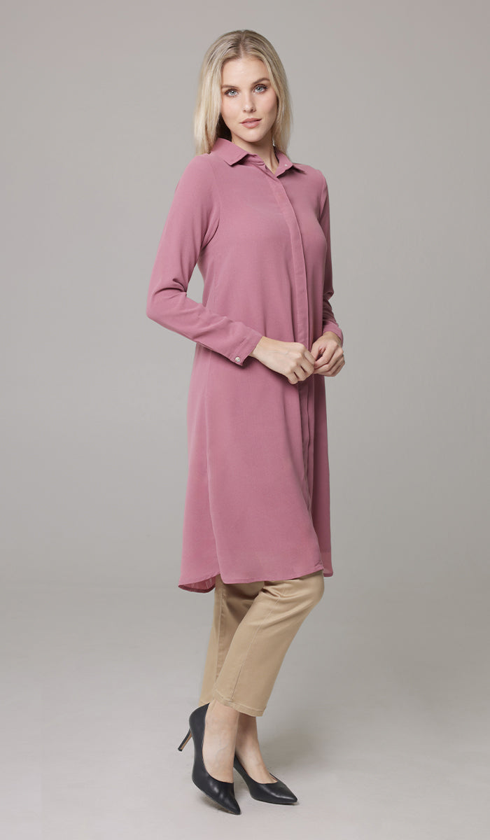 Full body view of woman wearing Asra tunic in Rose with khakis and heels. 