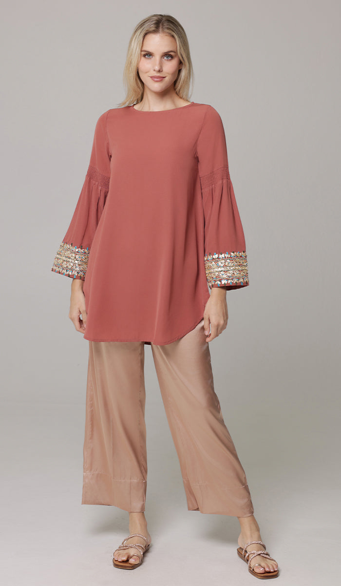 Woman wearing Esme tunic in Rose and Eva pants in Champagne.