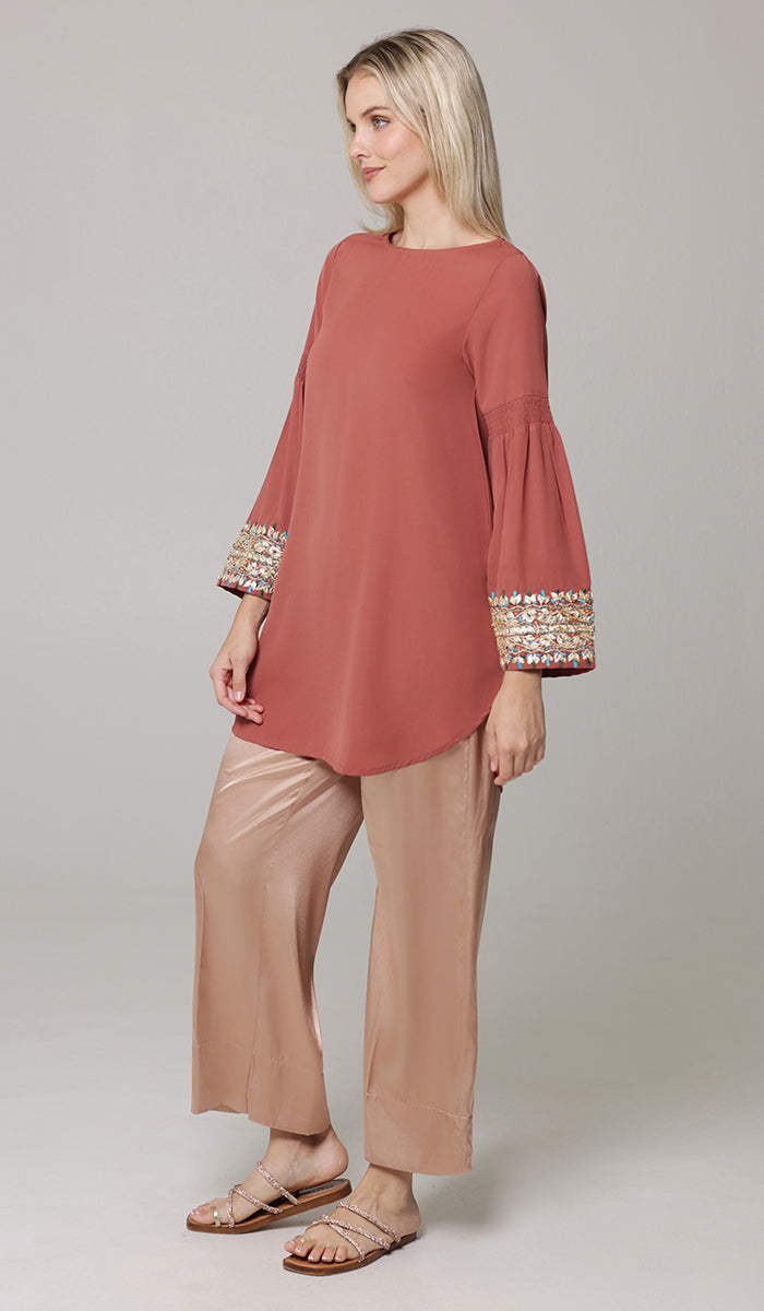 Woman looking to the side wearing Esme tunic in Rose. 