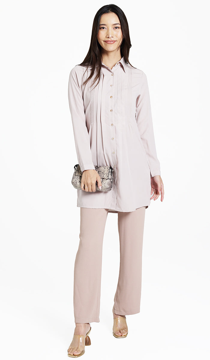 Woman wearing modest Hanane tunic in Blush with khaki pants and heels. 