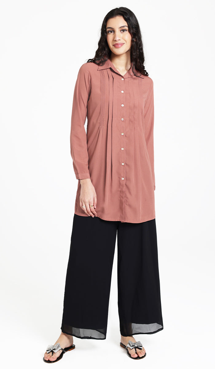 Woman wearing modest Hanane tunic in Rose with black pants and sandals. 