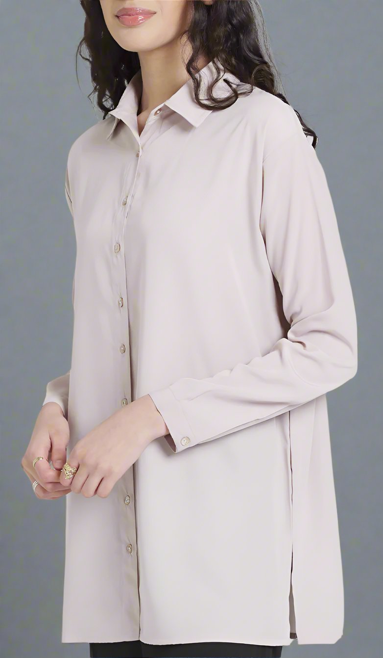 Female model wearing a blush Hania boxy button down side view.