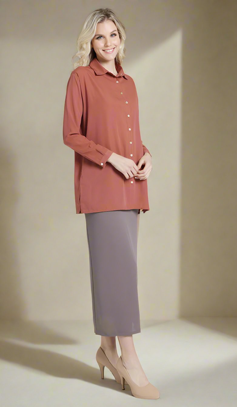 Full body side view of female model wearing a clay red Hania boxy button down with mocha pencil skirt.