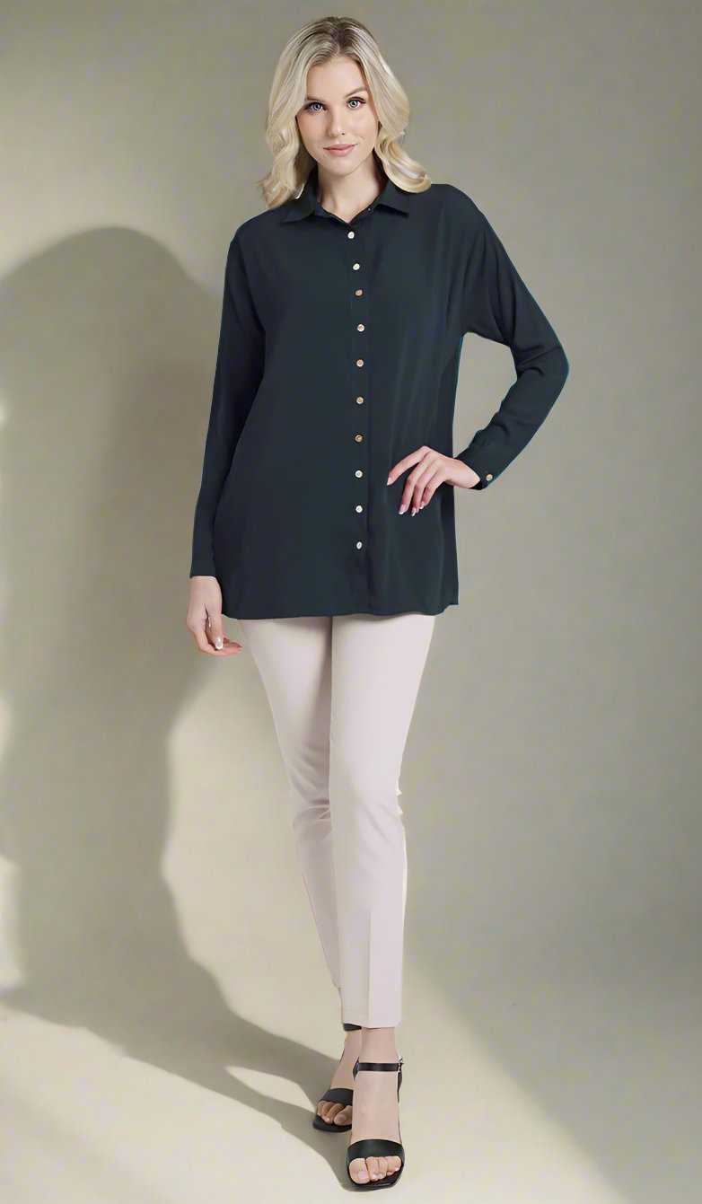 Full front view of female model wearing a dark teal Hania boxy button down with cream skinny pants. 