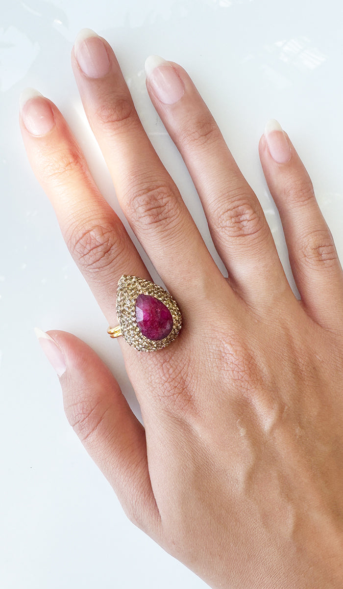 Hand wearing ruby teardrop ring.