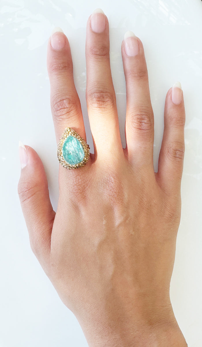 Hand wearing teardrop ring.