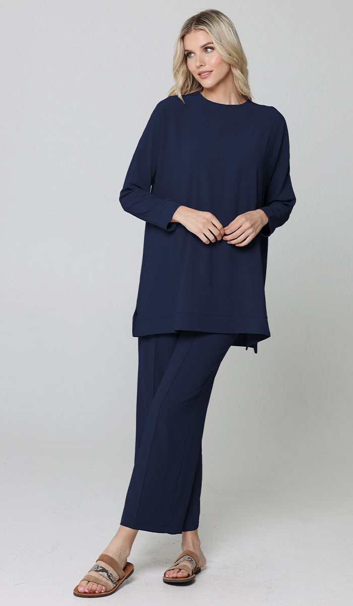 Woman looking to the side wearing Marvi tunic in Blue with Marvi pants and sandals. 