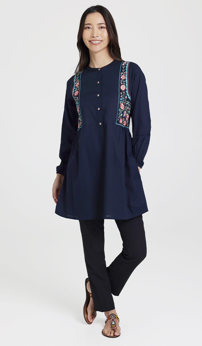 Smiling woman wearing modest Marzo tunic in Navy with black pants and sandals. 