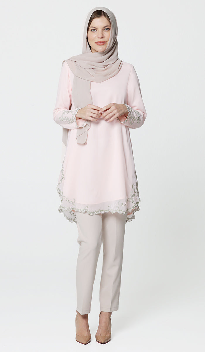 Model wearing hijab and modest Meena tunic in pink with pants and heels.