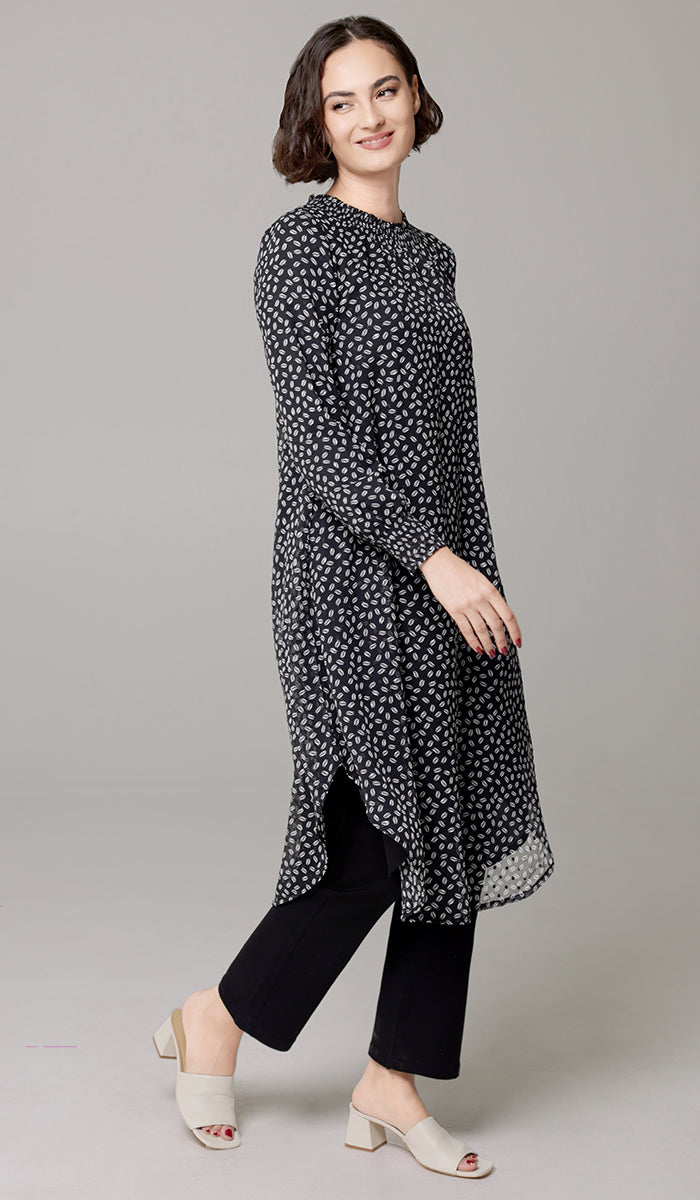 Side view of woman wearing Miral tunic in Black/White Dot. 