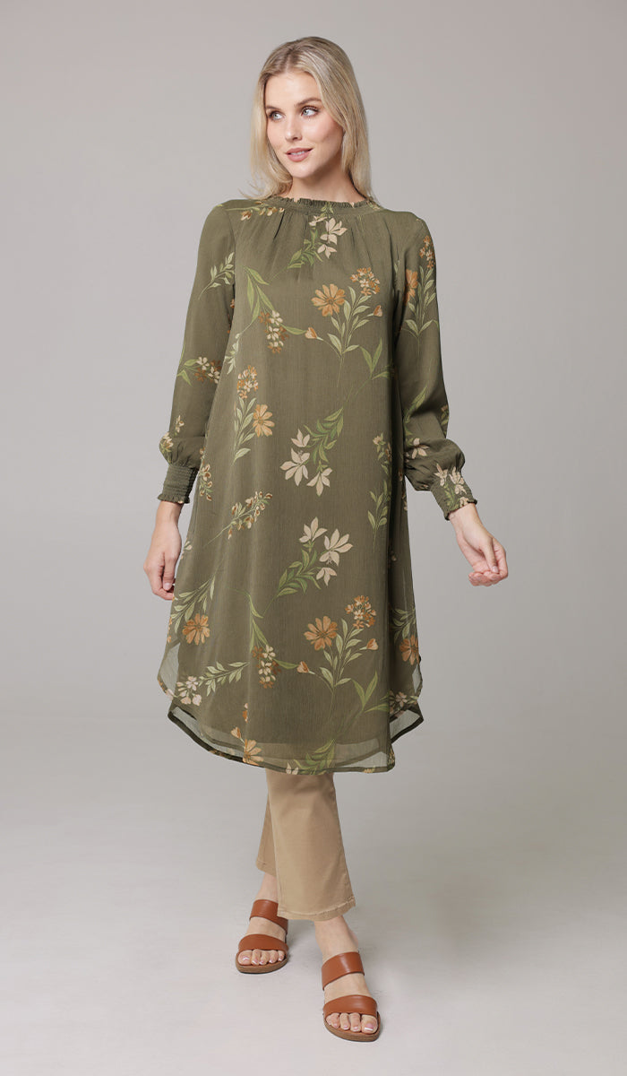 Woman wearing Miral midi tunic in Olive with khaki pants and sandals. 