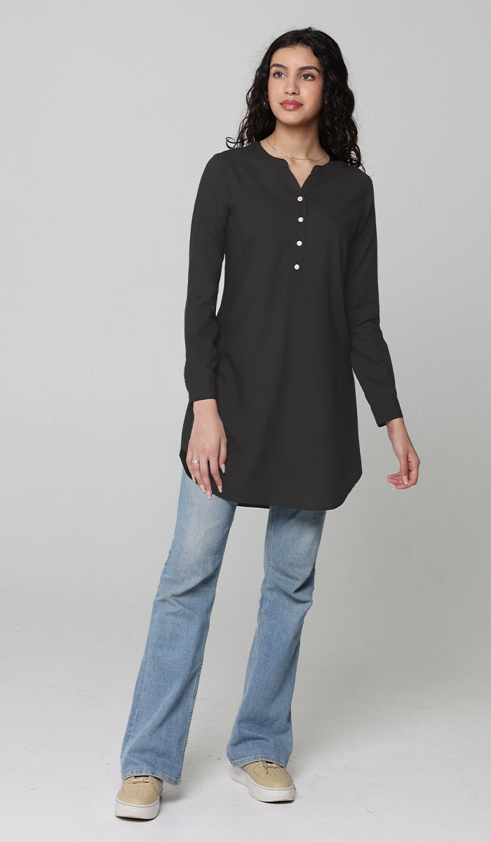 Woman wearing modest Parisa tunic in Black with jeans and sneakers. 