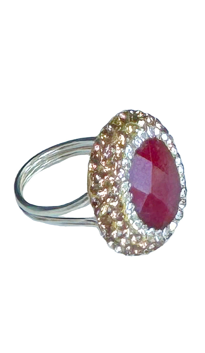 Side profile of oval ruby with silver and gold crystals.