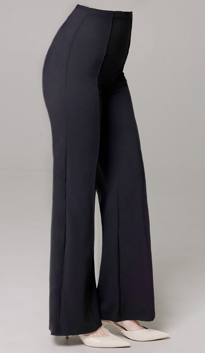 Woman wearing Riva pants in Black with white heels. 