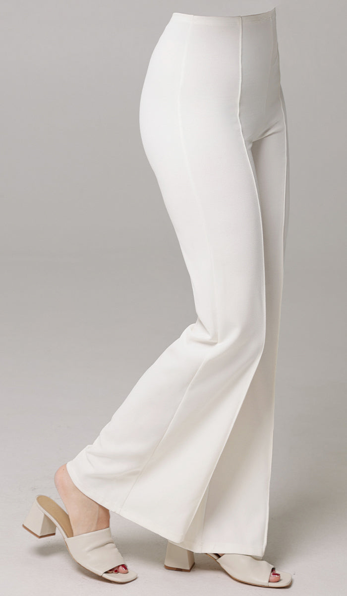 Side view of woman wearing Riva pants in White with heels. 