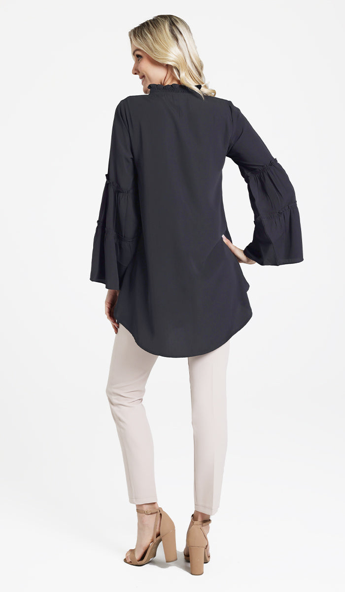 Back view of Saba tunic in Black with Alma pants and heels. 