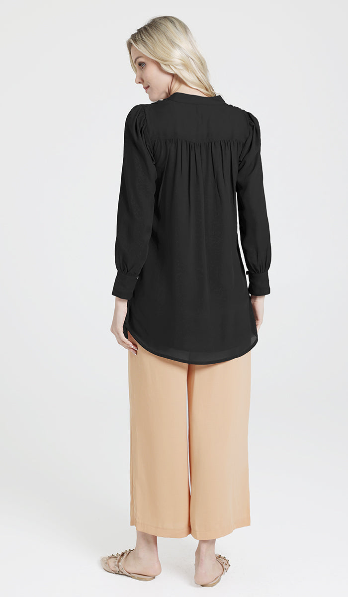 Back view of woman wearing Shaina tunic in Black with Ula pants and flats. 