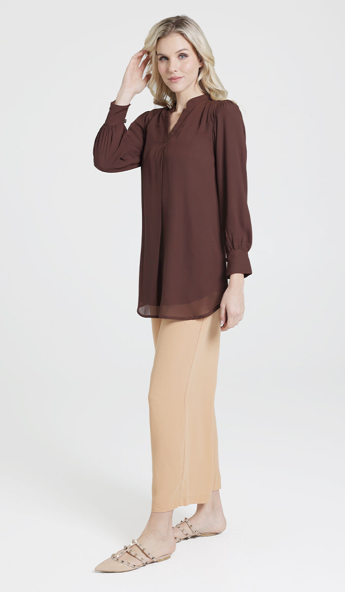 Full body side view of model wearing a brown chiffon Shaina top with light orange Ula pants.