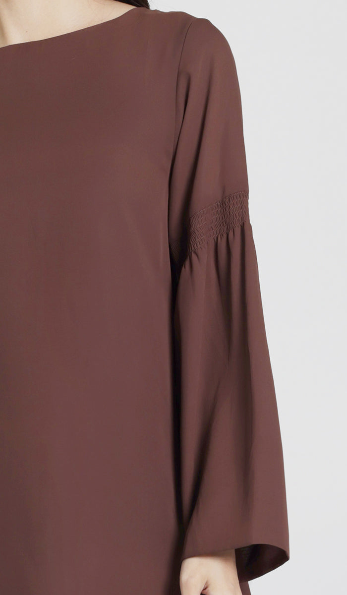 Up close sleeve details of brown tunic. 