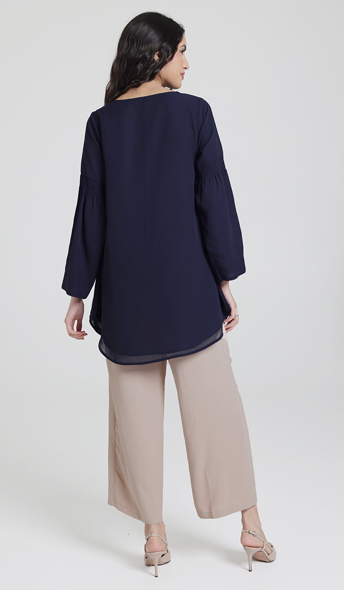 Back view of navy modest tunic, paired with khaki pants and heels. 