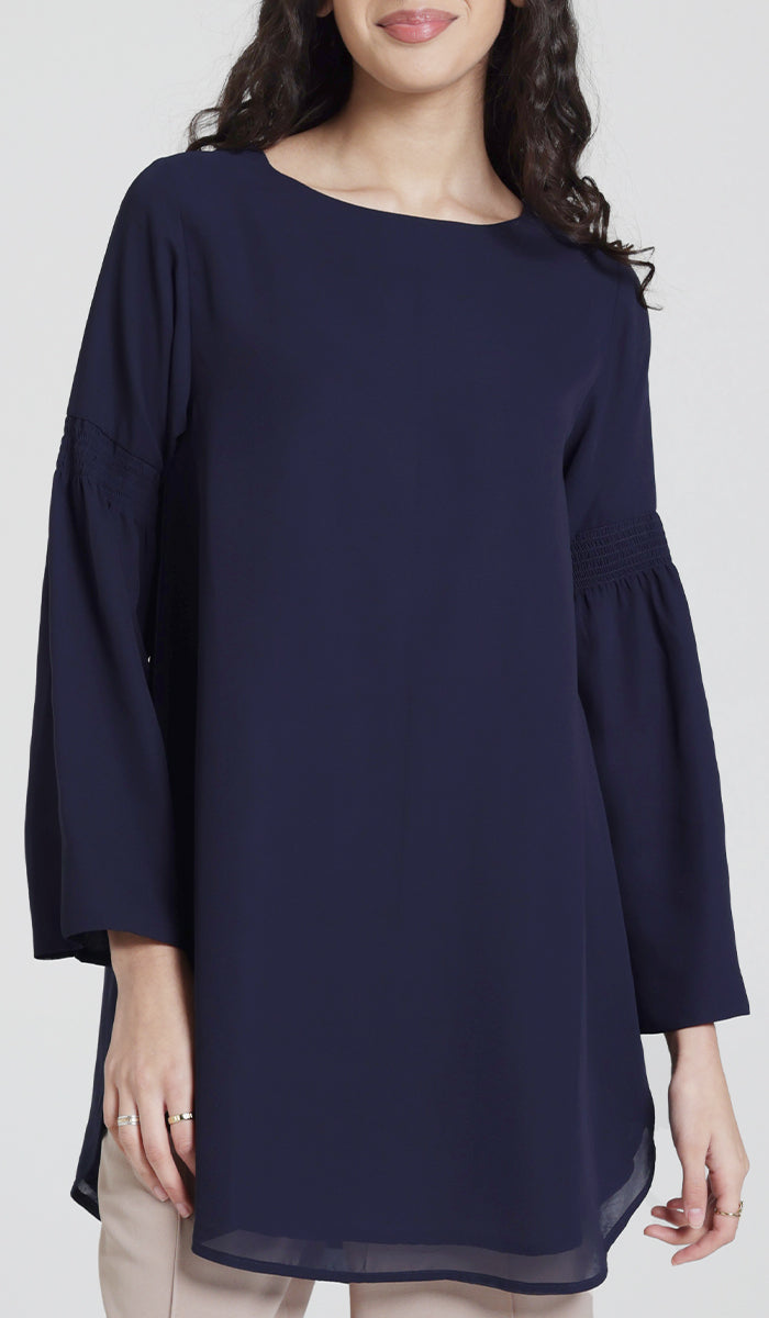 Model wearing modest navy modest tunic with bell sleeves. 