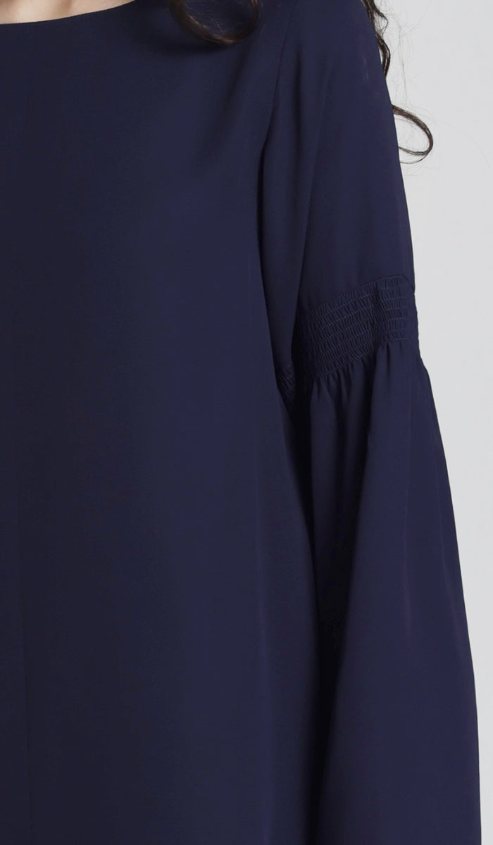 Close up sleeve details of navy tunic. 