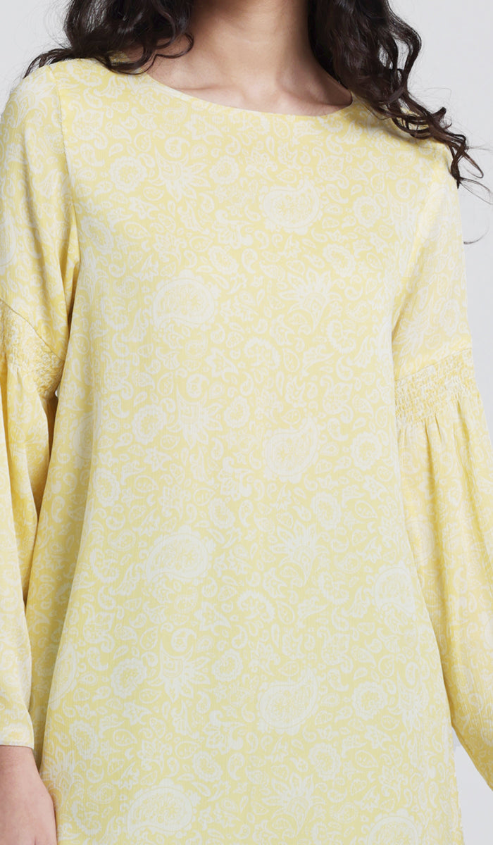 Up close details of yellow printed tunic. 