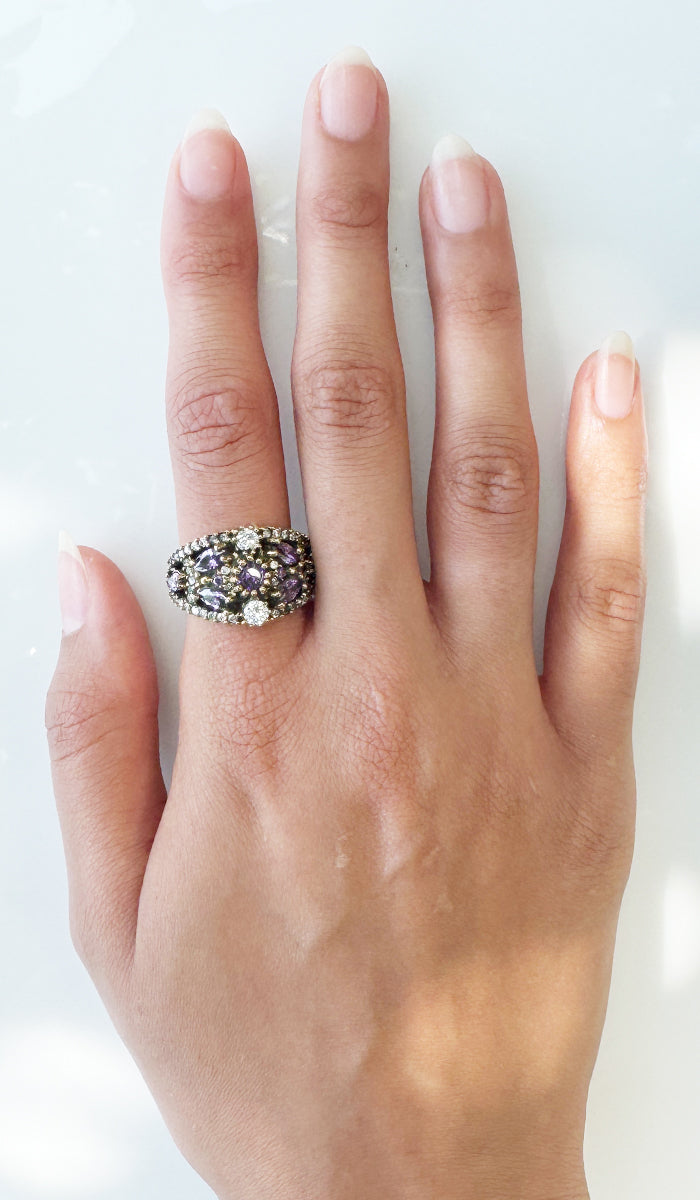 Hand wearing silver and purple ring.