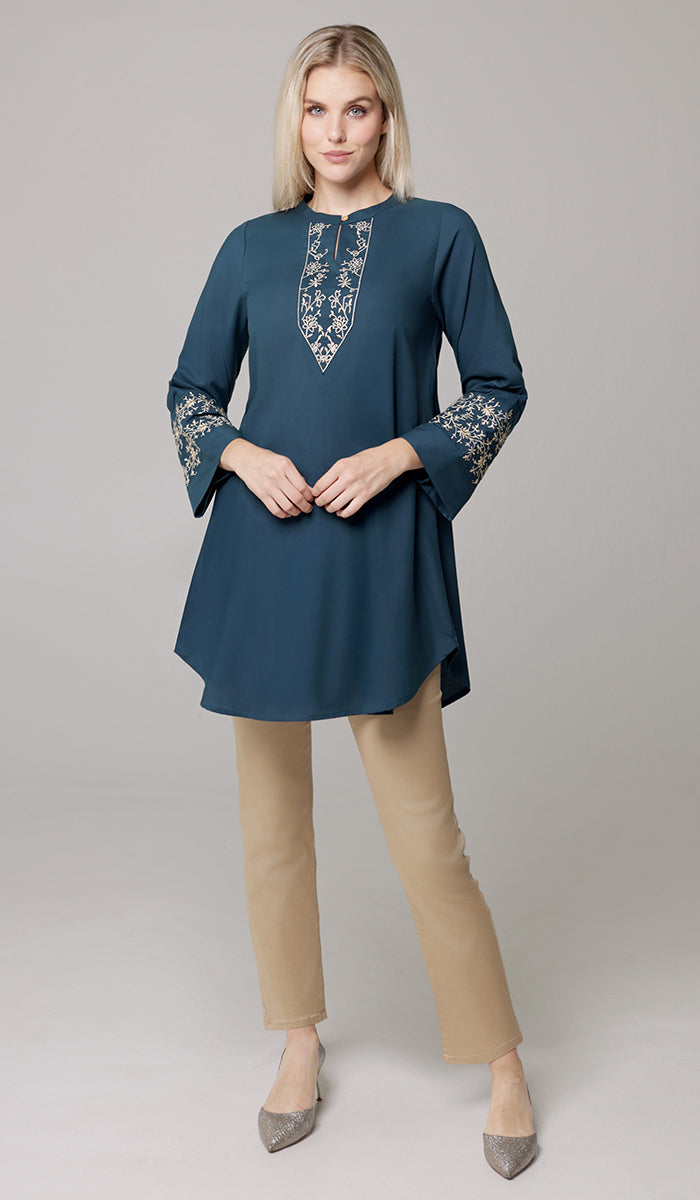 Woman wearing Zoha tunic in Teal/Gold with khaki pants. 