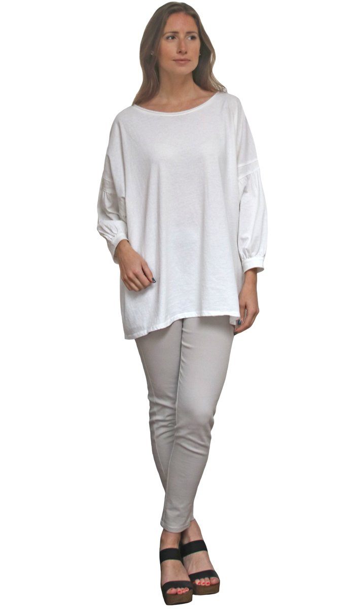 Woman wearing Aly Long Loose Modest Stretch Top in Cream with pants and heels. 