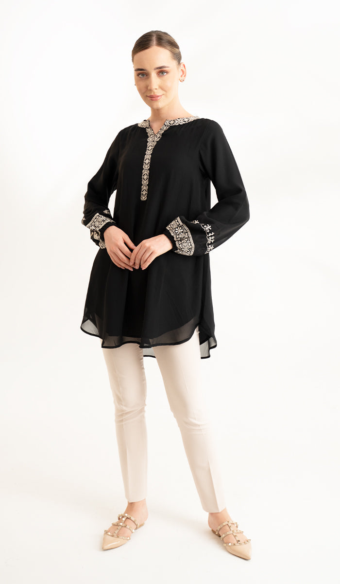 Smiling model wearing Amalie tunic in Black paired with khaki pants and flats.