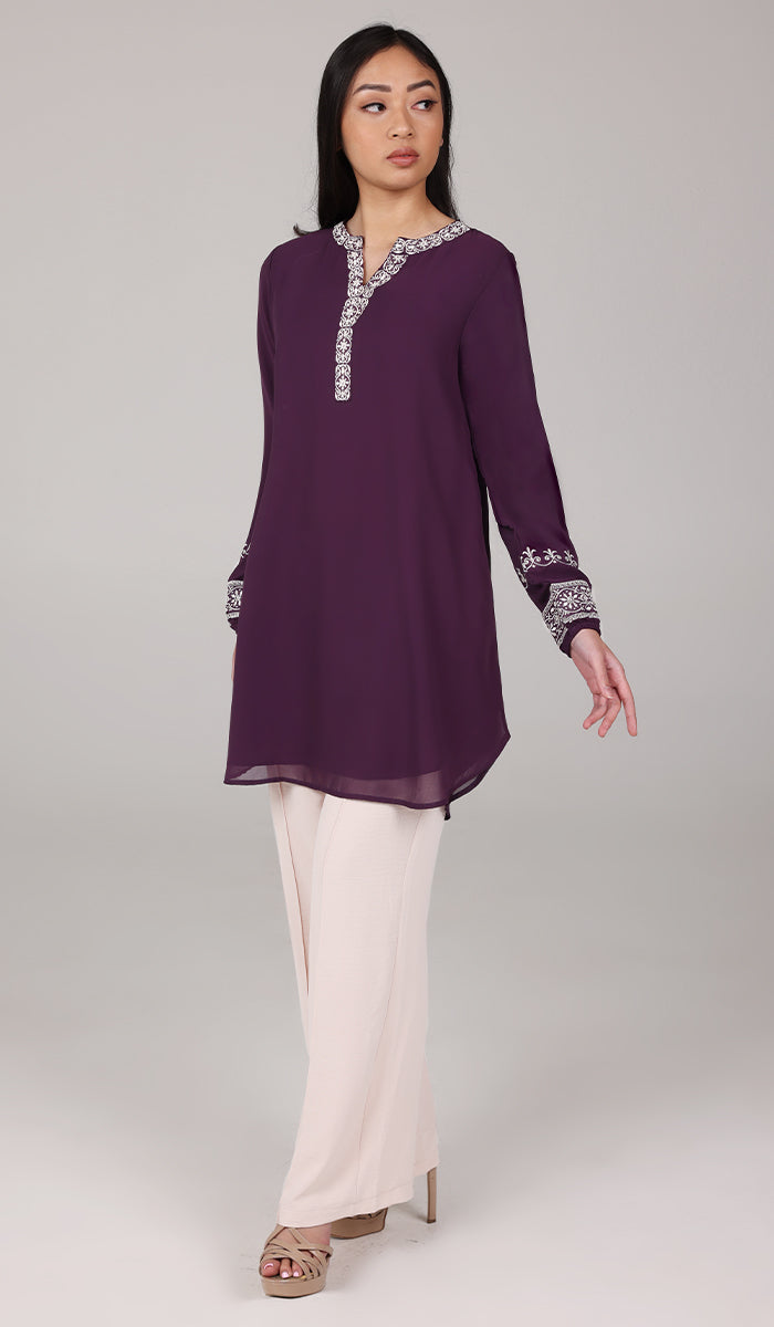 Woman looking to the side wearing Amalie tunic in Eggplant.